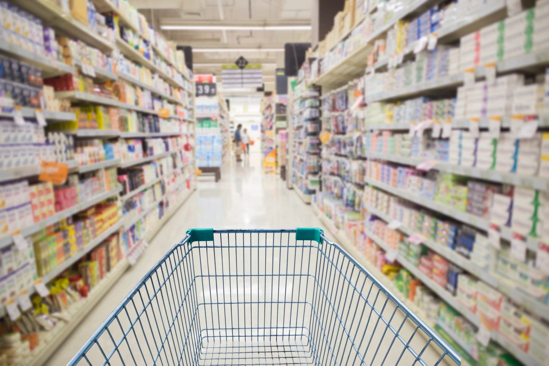 empty shopping cart in an aisle at a supermarket