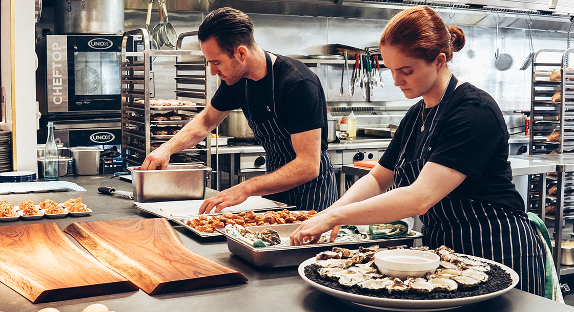 Two Chefs Making Food In The Restaurant Kitchen